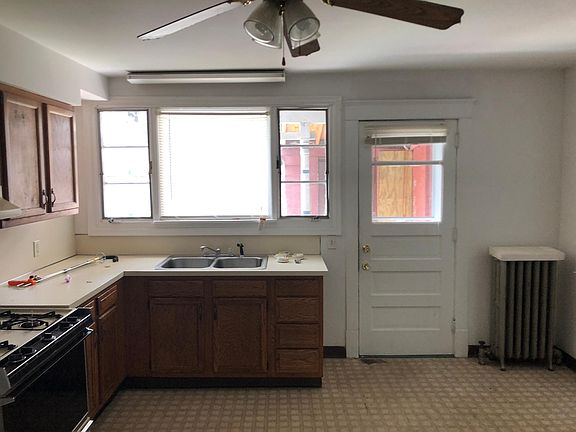 The kitchen before new appliances windows and floorIng. And rear door to back porch.