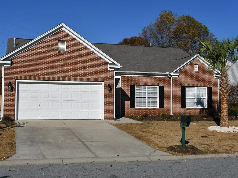 Brick veneer with two car garage. Majestic palmetto tree in