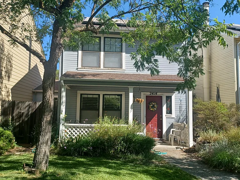 front of house, porch with bistro table, lawn area is shared with house next door.