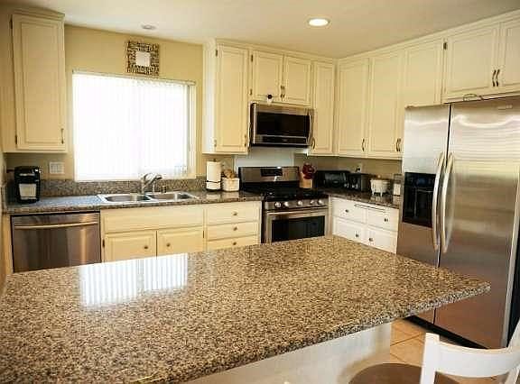 Remodeled kitchen with granite countertops and stainless steel appliances.