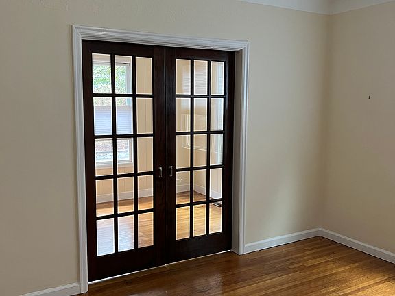 View into front room from front door with what could be a sleeping room with doors closed