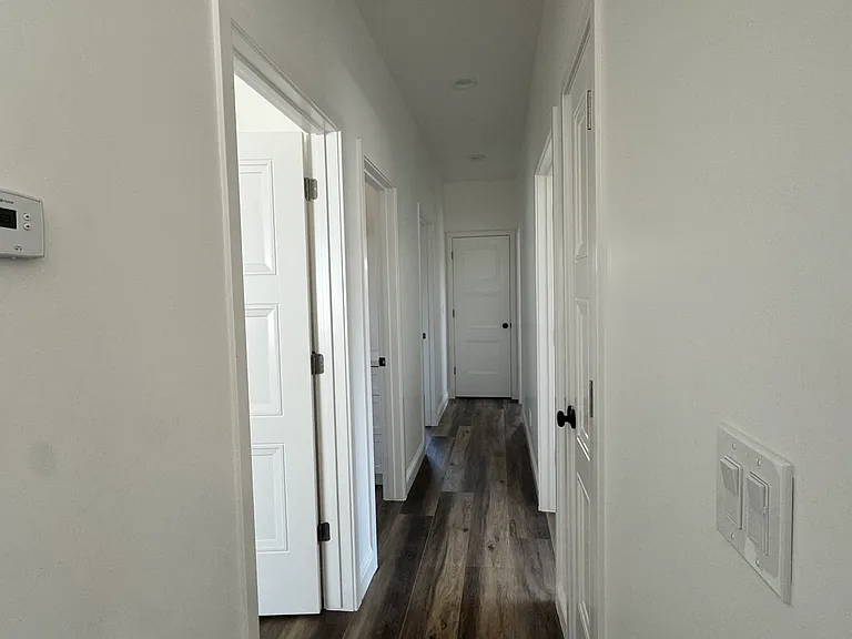 Same hallway with recessed lights and new thermostat facing rear of house.