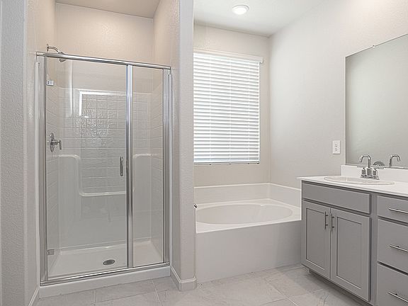 Primary bathroom with a duel sink vanity and stand alone bathtub.