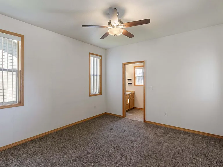 Master bedroom with master bath and ceiling fan. Lots of light and private entrance to the back patio.