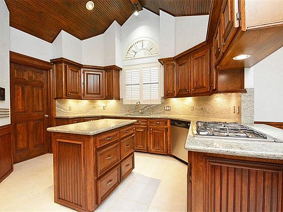 UPDATED ISLAND KITCHEN WITH VAULTED BEADBOARD CEILING, PLANTATION SHUTTERS, IN '08 GRANITE, TILE FLO