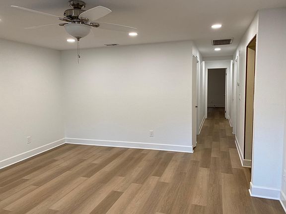 Living room with view down the hallway to the kitchen, main bathroom and 3 bedrooms
