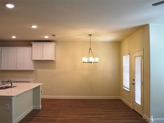 Kitchen with white cabinetry, a chandelier, recessed lighting, dark wood-type flooring, and hanging light fixtures