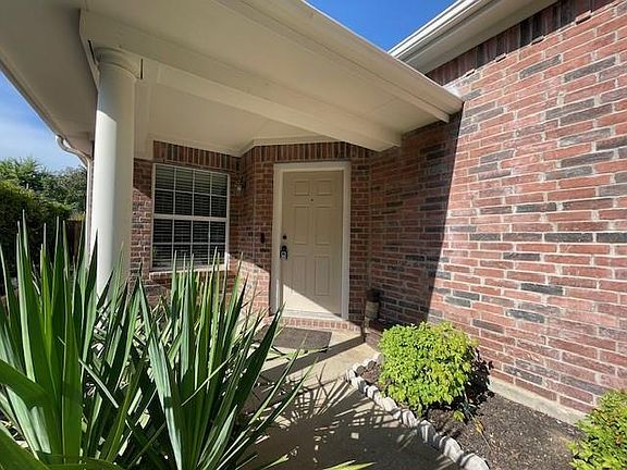 Entrance to property featuring brick siding
