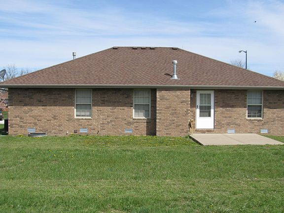Rear of house showing patio for grilling, outdoor seating.
