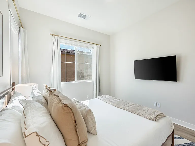 Bedroom 3 is filled with natural light and offers a Queen-size bed, a wall-mounted smart TV, and a generously sized mirrored reach-in closet!