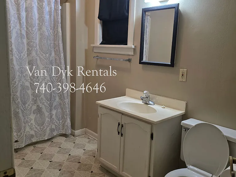 Large bathroom, tub/shower, vanity, toilet.