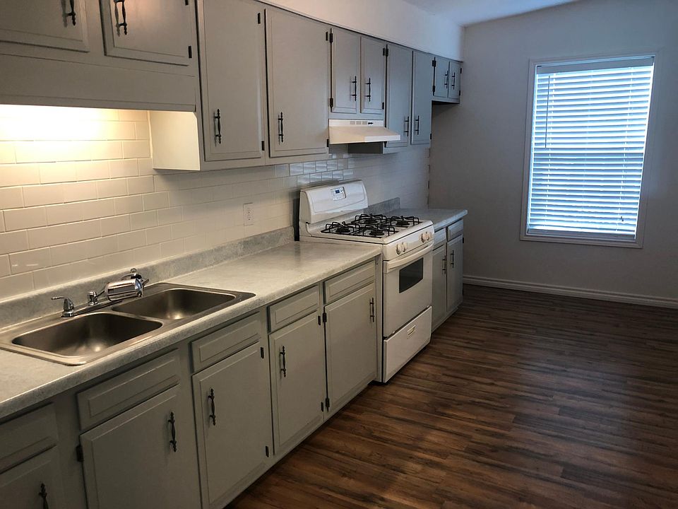 Kitchen with gas stove. Opens to living room.
