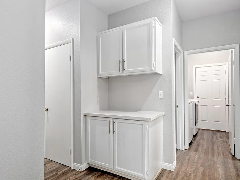 Hallway with linen cabinets and closets
