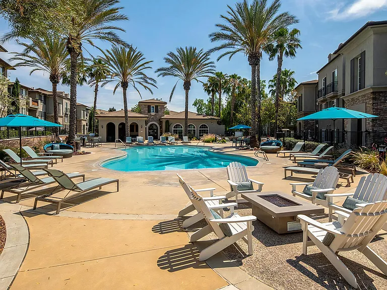 Expansive Pool Deck Featuring Firepit, Lounge Chairs, and Palm Trees