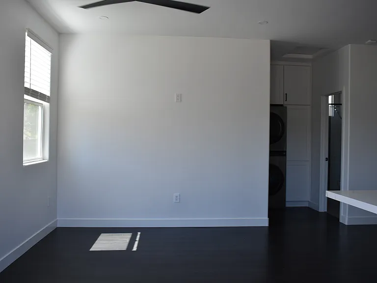 Enter front door to living room area with bright natural light.