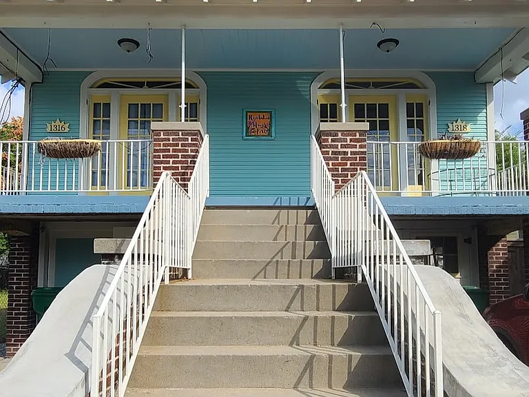 Exterior stairwell entry at front of house. 
1318 is on the right and includes the right side of the front porch area.
1 assigned parking spot is to the right of the stairwell.
