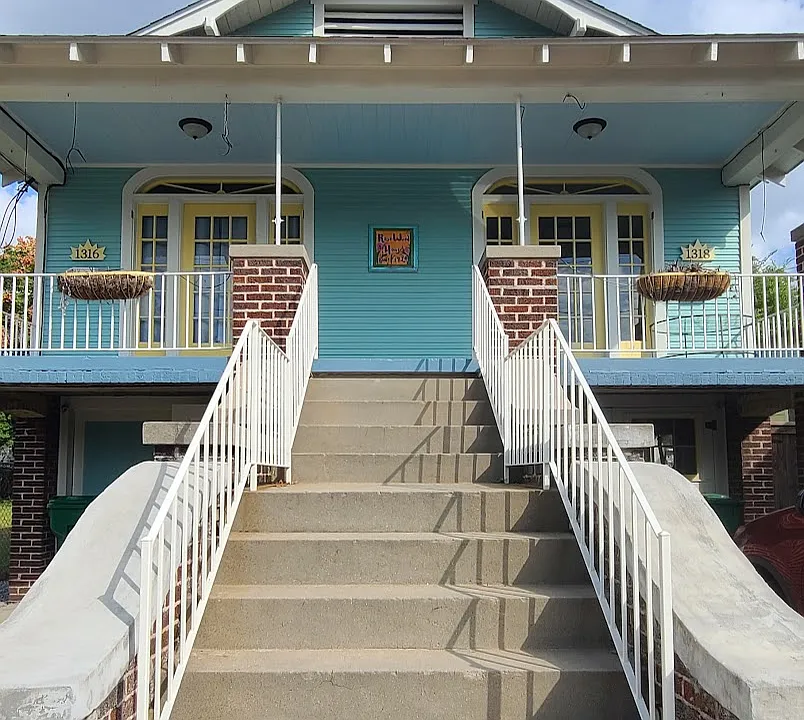Exterior stairwell entry at front of house. 
1318 is on the right and includes the right side of the front porch area.
1 assigned parking spot is to the right of the stairwell.