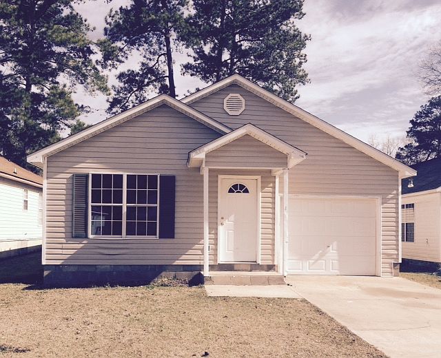 Front of cottage home with one car garage.