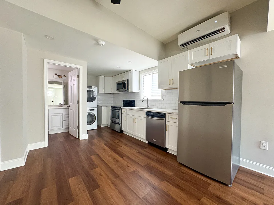 White shaker kitchen with stove, microwave, dishwasher, and refrigerator.