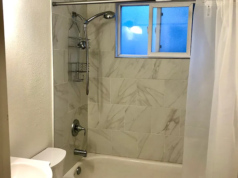 Newly tiled bathroom with updated features, clean and fresh!