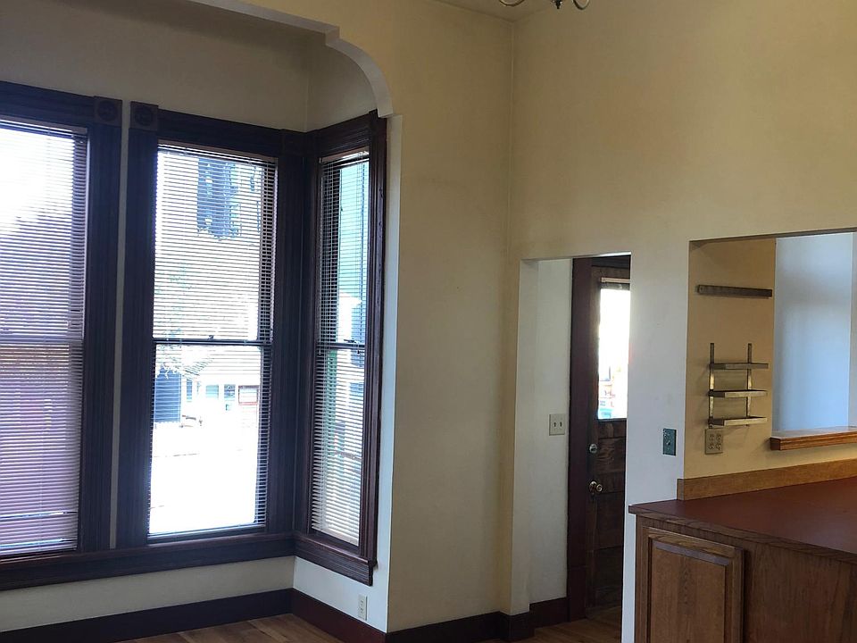 Large living room with square bay, foyer and open kitchen