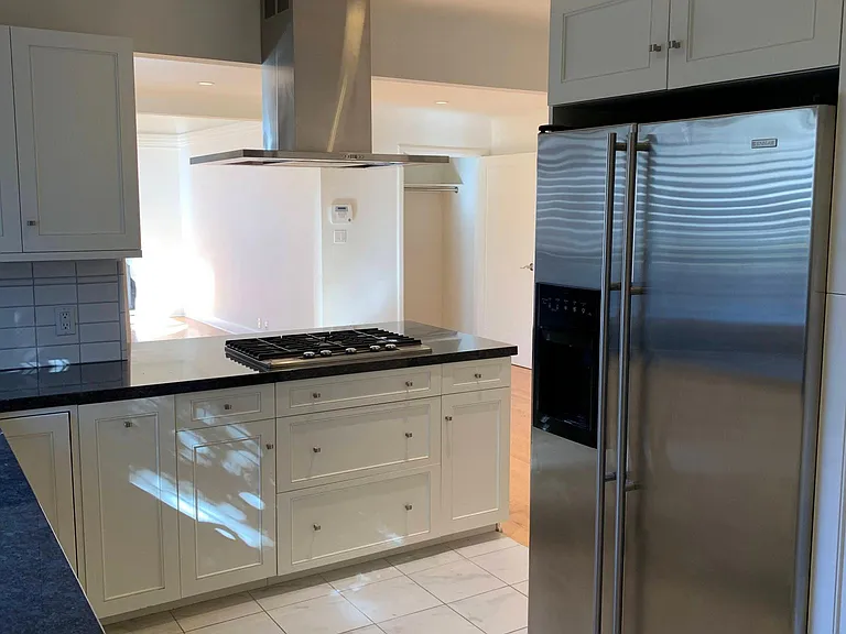 Kitchen with stainless cooktop and French-doored refrigerator