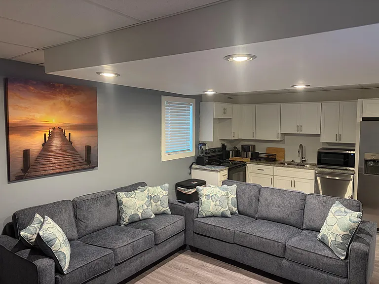 Open-concept living area with a sectional sofa, recessed lighting, and quick access to a full kitchen with ample cabinets.