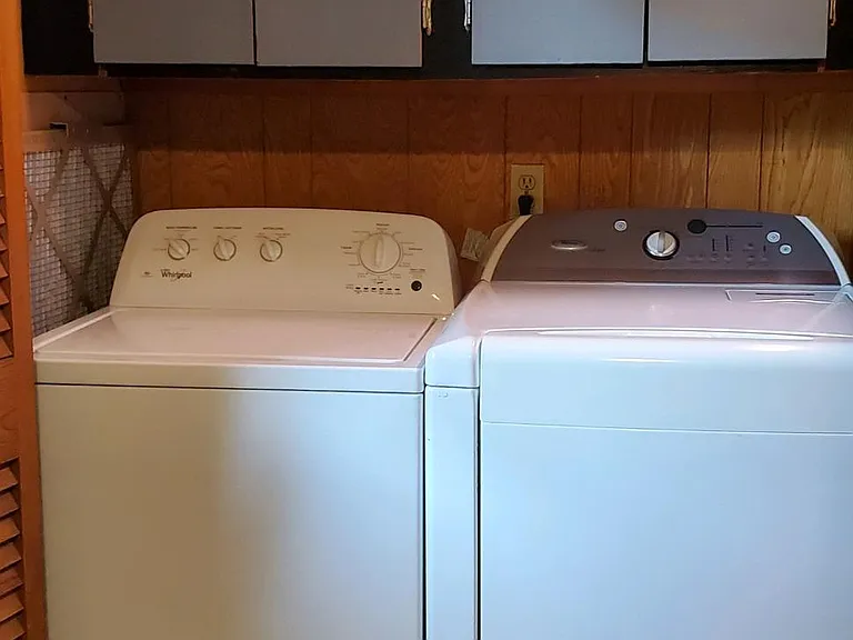 Laundry next to the kitchen with wooden shutter doors