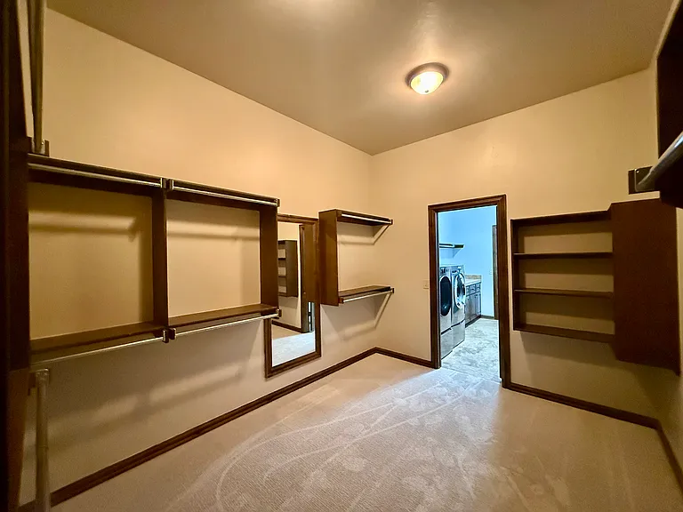 Check out the size of your walk-in closet. Not pictured are closet rods that are higher up for hanging long items. Tons of storage, a large full-length mirror. Newly installed carpet and fresh paint to brighten the room.