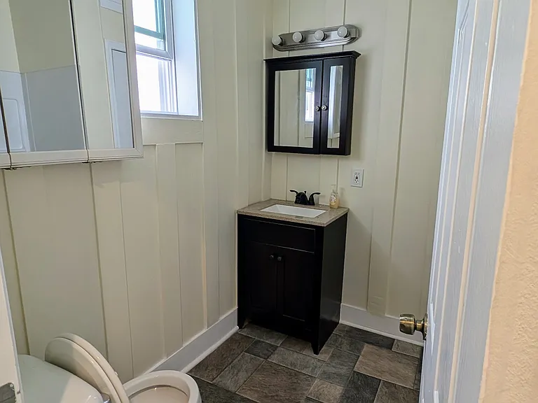 Fully remodeled bathroom with updated flooring, stylish vanity, and sleek fixtures_all in a clean, neutral palette.