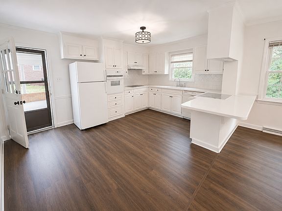 Freshly painted kitchen with new flooring. The kitchen opens into the family room with fireplace.