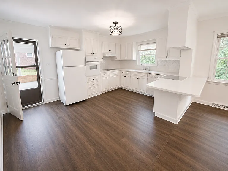 Freshly painted kitchen with new flooring. The kitchen opens into the family room with fireplace.