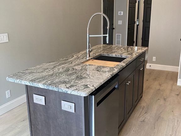Kitchen island with stainless steel dishwasher and built in cutting board