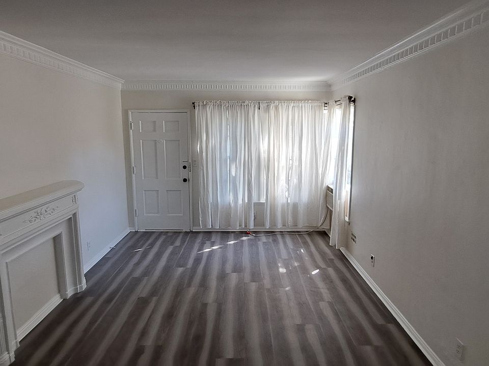 Living room 18'x12' square feet with new curtains and window AC. Faux Fire place and new floors.