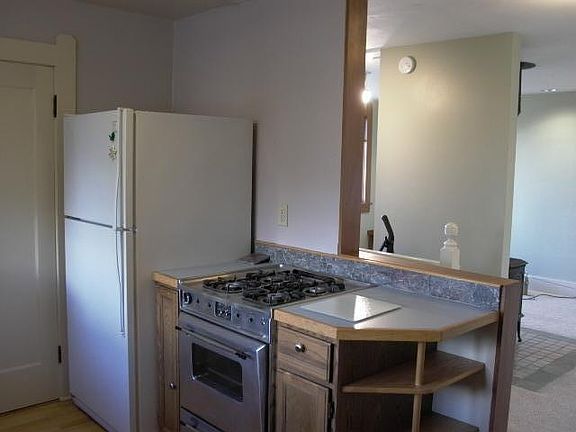 View to southeast from kitchen over stairwell to that goes down to entry, and further to the right into the living and dining room space.