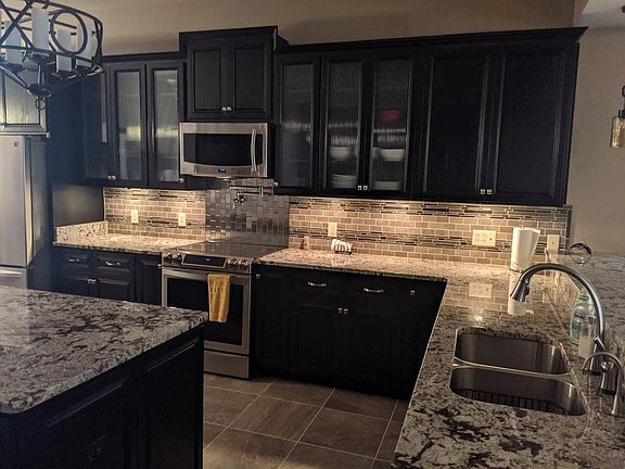 The kitchen features and Induction stove and two sinks. There is a full wall of cabinetry on the opposite side of the island.
