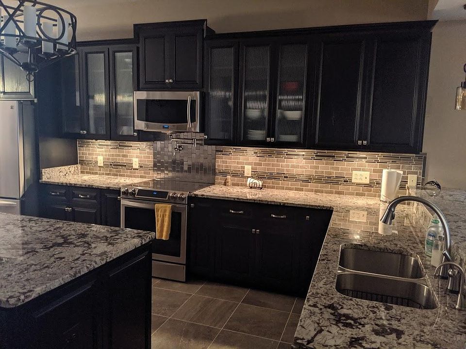 The kitchen features and Induction stove and two sinks. There is a full wall of cabinetry on the opposite side of the island.