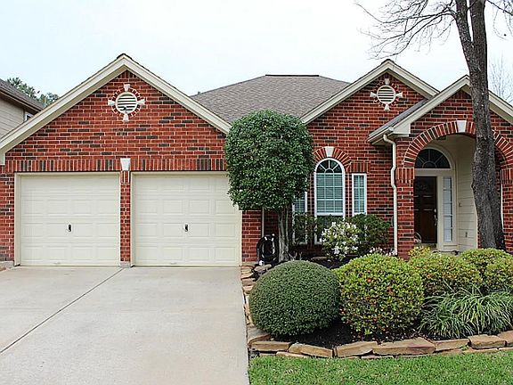 Driveway for two car garage. Green landscaping all through the front yard.