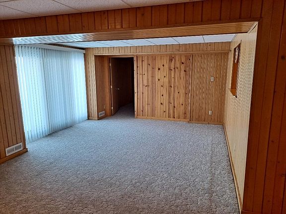 Living room leading to den. Patio door leading to outdoor patio and a beautiful view.