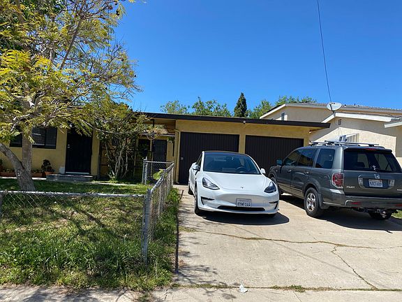 entrance is to the left of the garage door under the arch.
