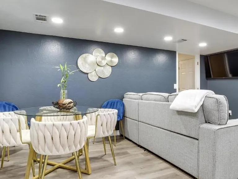 Open-concept living and dining area with recessed lighting, durable wood-look floors, and a wall-mounted TV.