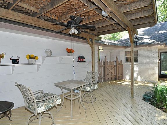 Backyard covered deck area off the detached garage overlooking landscaped backyard