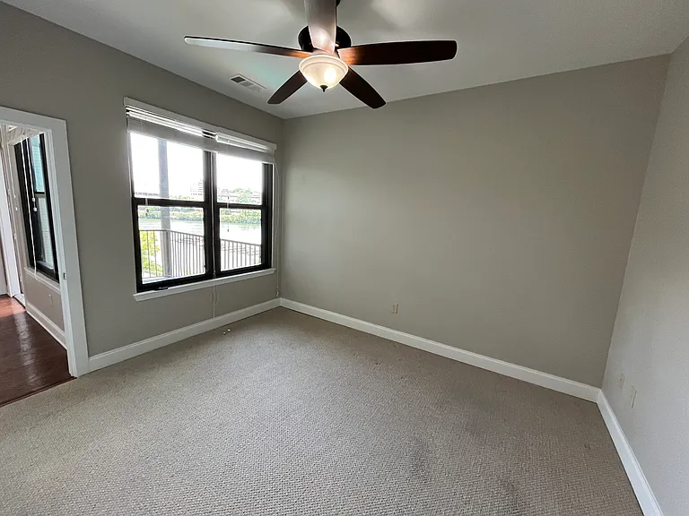A luxurious master bedroom with a water view is designed to feel like a private retreat while still offering comfort and functionality expected in a high-end rental. Natural light fills the room throughout the day, providing calmness and relaxation.