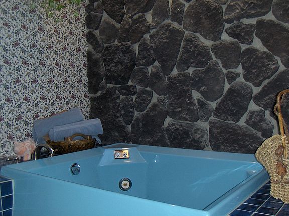master bath with jet tub and tile and stone surround