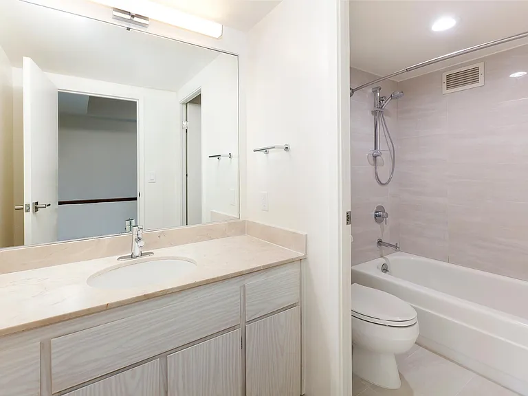 A chic and stylish full bathroom, with a sliding glass divider and a fully functioning bath tub. This is a combination of wide range, and heavy duty bathroom parts.