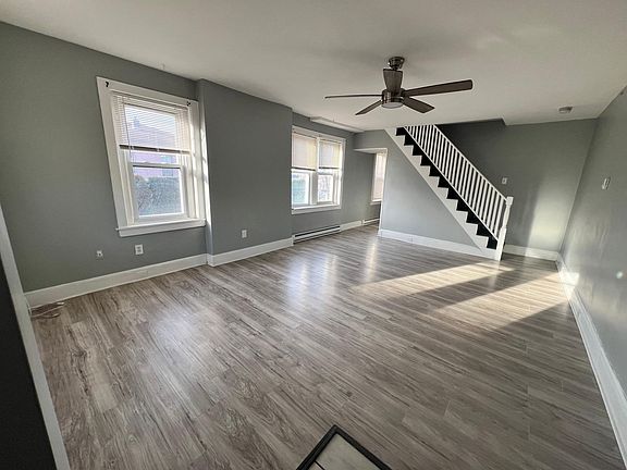 Spacious living room w/ coat rack and tons of lighting.
