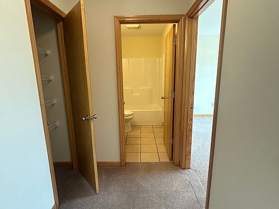 Hallway leading to full size bathroom, front bedroom and linen closet.