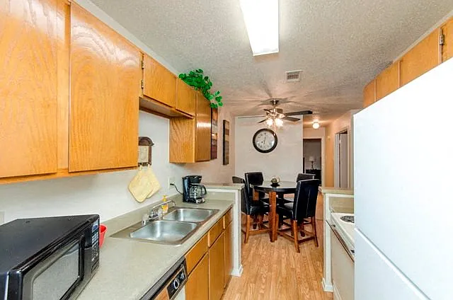 Kitchen with Hardwood-Style Flooring, Wood Cabinetry, and White Kitchen Appliances