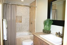 Hall Bath with Pebble Wall and Limestone Counter