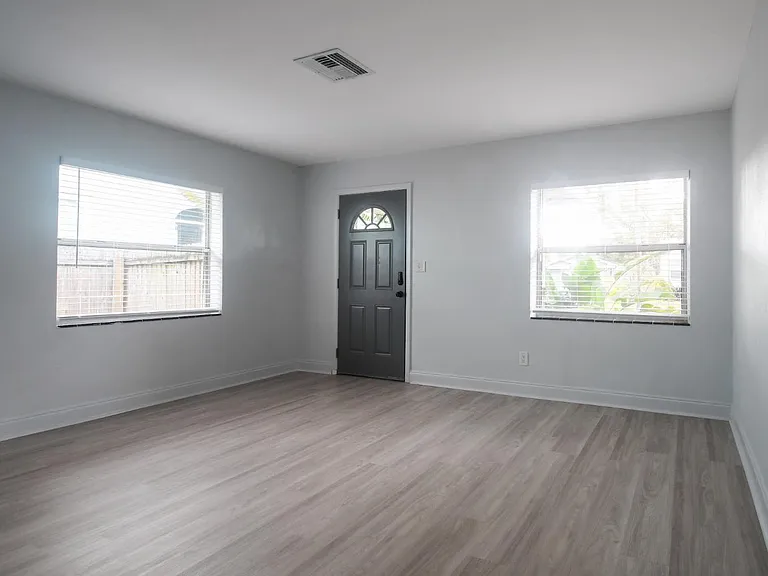 Looking towards the front door across the living room. From the front door, you step onto a covered, Mexican-tiled front porch. Brand new low-e, double pain windows throughout unit.
